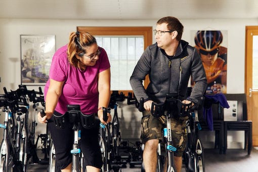 Two people using exercise bikes