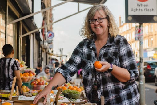 Lady purchasing fruit from a market stall