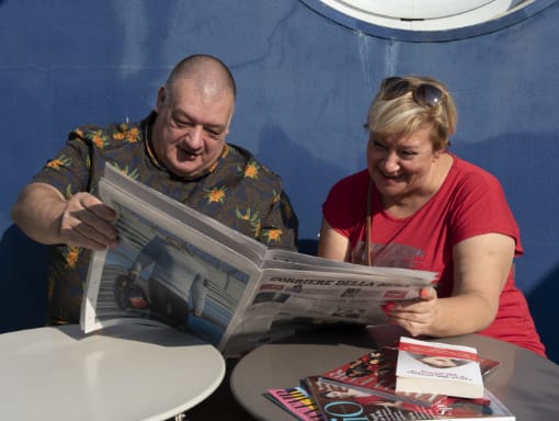 A man and a woman reading a newspaper.